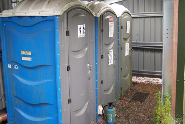 Three portaloos inside a building